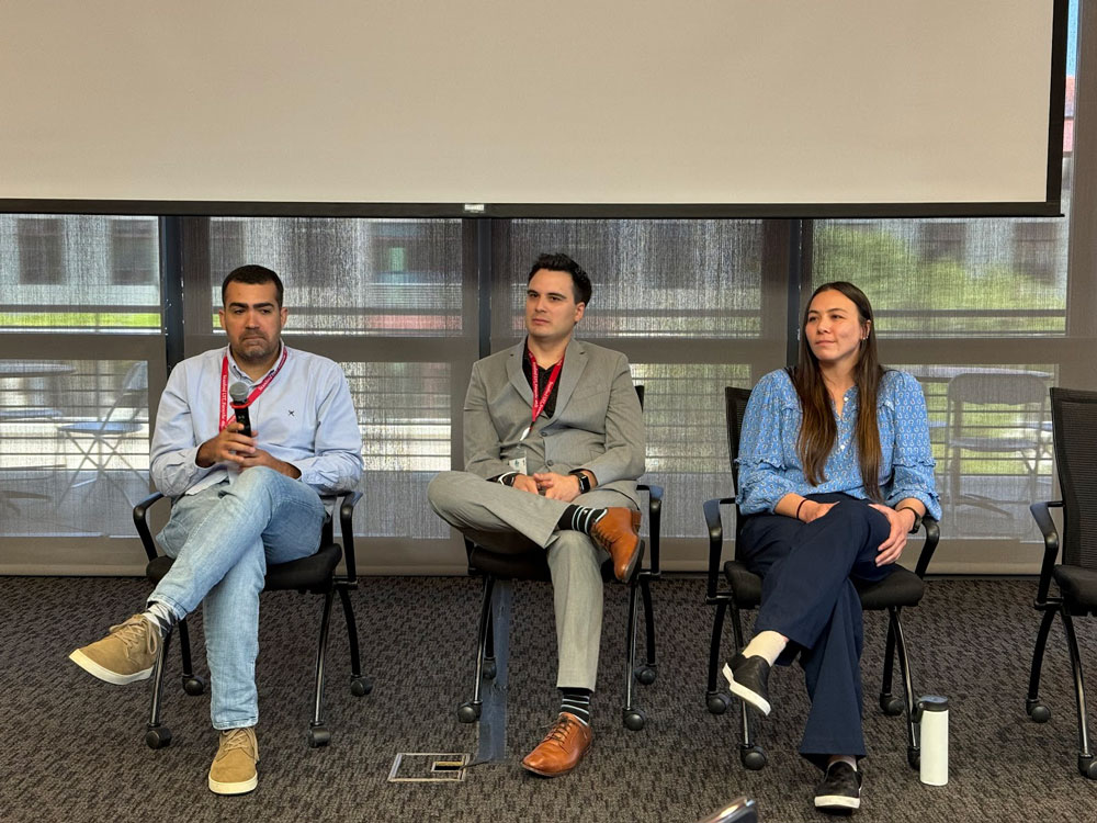 Group of three panelists presenting in front of professionals.